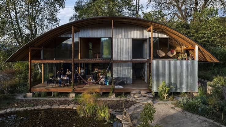 Maison en bois et en verre sous une serre